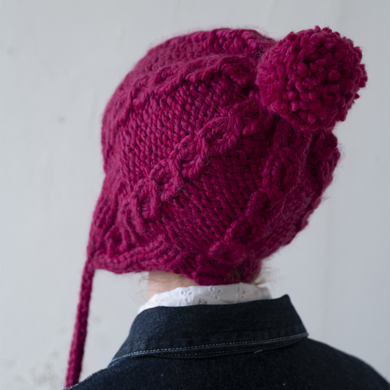 手編み、ピンクのぶら下がるボンボンつき帽子。 - ニットキャップ